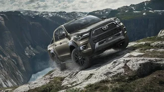 Toyota Hilux in felsigem Offroad-Gelände vor Bergsee und Bergkuppen