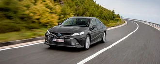 Grauer Toyota Camry auf in einer Landstraße in einer südländischen Stadt