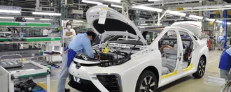 Ein Mechaniker repariert einen weißen, auseinander gebauten Toyota